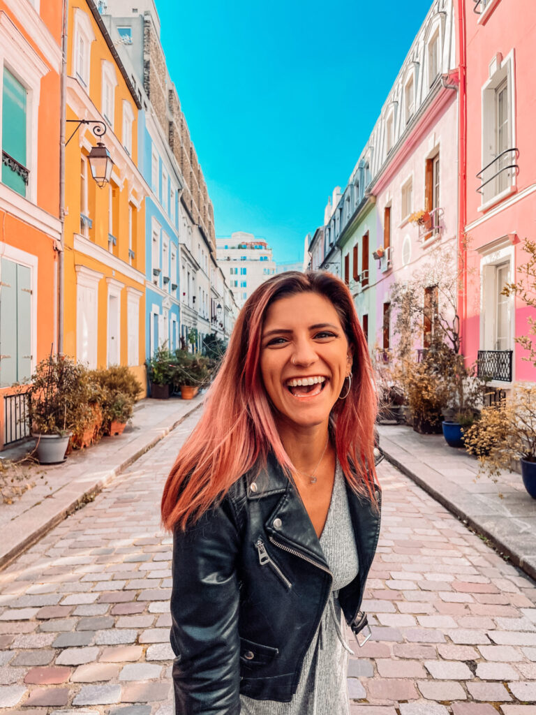 girl laughing in front of colorful houses